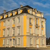 Rechter Seitenflügel des Schloss Augustusburg in Brühl. Die Fassaden sind in Gelb und Grau gehalten.